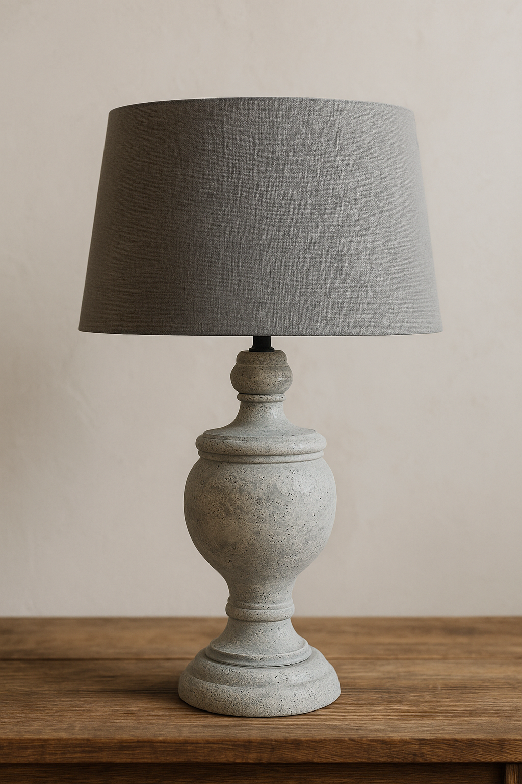 Grey table lamp with textured base and fabric shade on wooden console