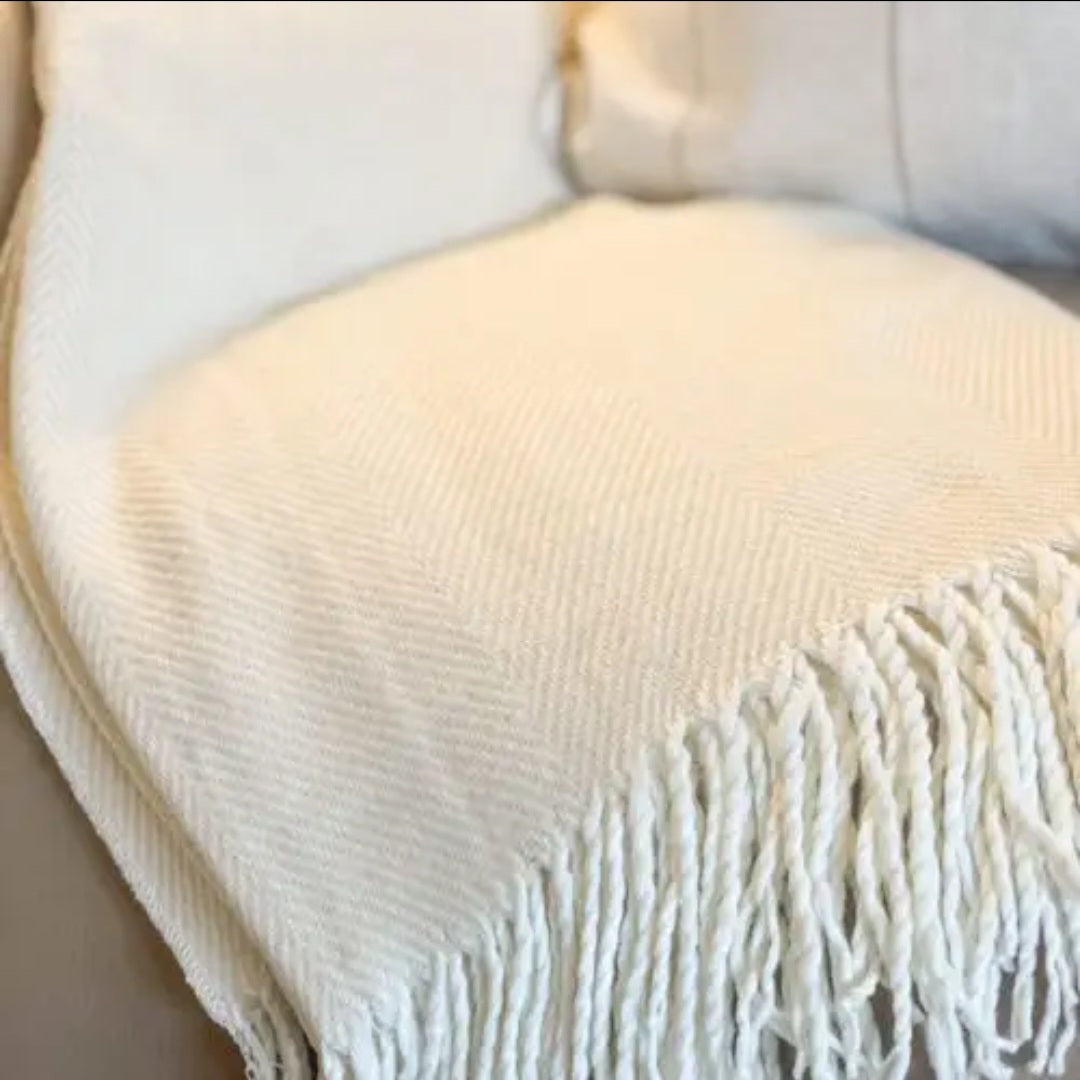 Cream-beige tassel throw blanket styled for a sofa—cosy, versatile neutral accessory for modern country interiors.