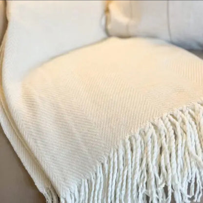 Cream-beige tassel throw blanket styled for a sofa—cosy, versatile neutral accessory for modern country interiors.