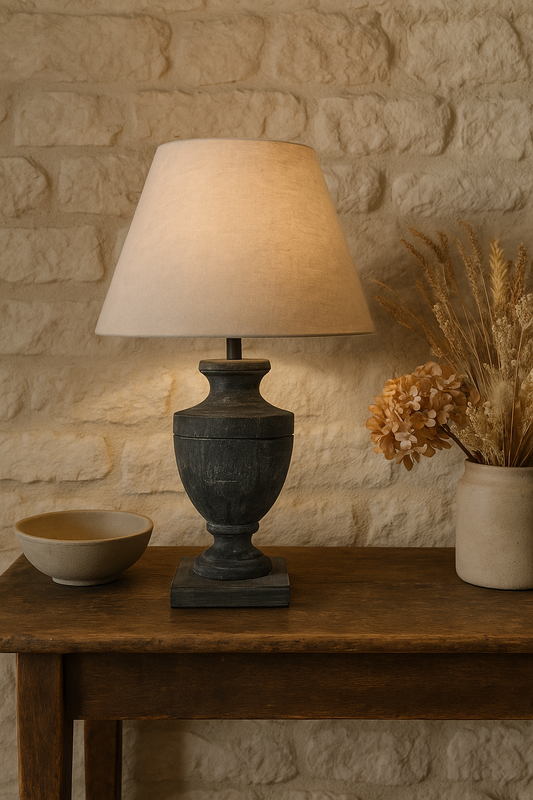 Neutral 34 cm Avia table lamp with 49 cm shade, styled in a cosy country cottage interior with white stone walls and aged wood, available from Doyle’s Lodge Interiors in Ireland and the UK.