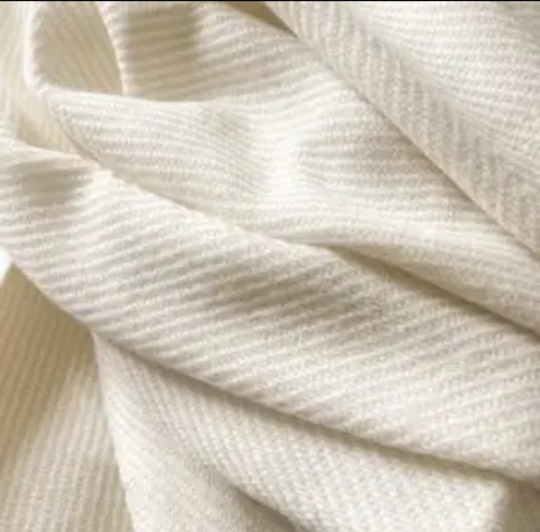 Neutral cream and beige tasselled throw blanket, soft polyester—perfect for adding warmth to sofas, beds and armchairs.